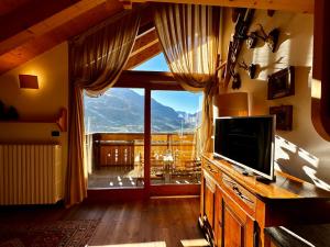 a living room with a tv and a large window at Alpine Escape 4 in Bormio