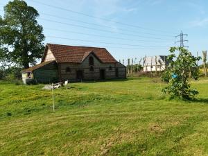 an old house in a field with a grassy yard at La Chèvrerie de Saint-Vigor in Saint-Vigor-dʼYmonville