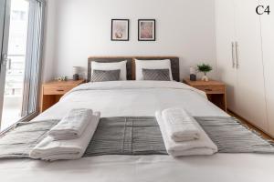 a bedroom with a large white bed with towels on it at Waylink Residences - Marina Floisvou in Athens