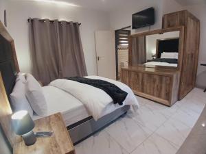 a bedroom with a large bed and a large mirror at The Throne Goc Guesthouse in Johannesburg