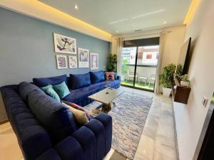 a living room with a blue couch and a table at The Sapphire Suite - 2 BR Near Beach & TGV Station in Tangier