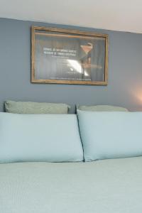 - un lit avec deux oreillers et une photo sur le mur dans l'établissement #Grand#Cocooning#Biendormiracognac, à Cognac