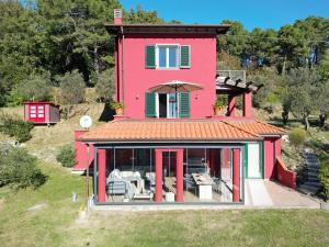 ein rosafarbenes Haus mit einer Terrasse in der Unterkunft Torre Rossa in Fosdinovo