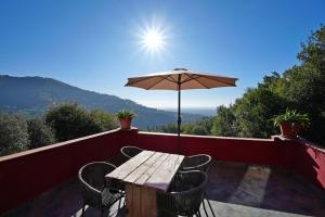 einen Tisch und Stühle mit Sonnenschirm auf dem Balkon in der Unterkunft Torre Rossa in Fosdinovo