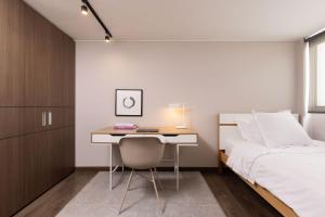 een slaapkamer met een bed en een bureau en een bed en een bed bij Bogo64 in Bogota