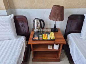 a table with a coffee pot on it next to two beds at Thanh Tâm Hotel in Ho Chi Minh City
