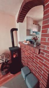 a brick fireplace in a kitchen with a stove at Vikendica Alisa in Doboj +29 photos