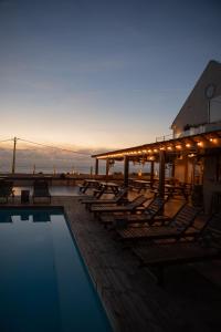 a pool with chaise lounges and chairs on a pier at Lapoint Surf Camp Ericeira in Ericeira