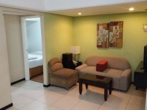 a living room with a couch and a chair and a table at Ralph Anthony Suites in Manila