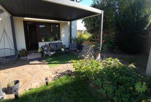 a patio with a black awning and some plants at Ferienwohnung nahe Meißen in Nünchritz
