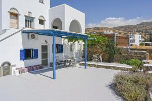 a patio with a blue canopy in front of a house at La Luna in Agia Barbara Tinos in Agios Sostis