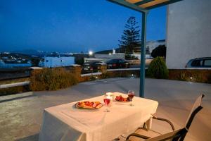 a table with two plates of food and two glasses of wine at La Luna in Agia Barbara Tinos in Agios Sostis