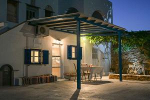 a pergola on the side of a house with a table at La Luna in Agia Barbara Tinos in Agios Sostis +21 photos