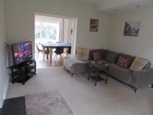 a living room with a couch and a table at Large 4 bed detached house with parking in Newark-on-Trent