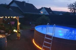 a pool with a ladder in a backyard at night at NEU! Ferienwohnung Beim Hubert in Waldbröl