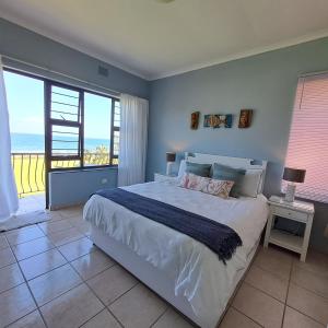 a bedroom with a bed with a view of the ocean at 10 Seaverge in Port Edward