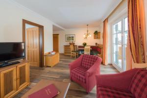 un salon avec un canapé et une télévision dans l'établissement Landhaus St. Georg, à Obertauern