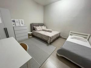 a small bedroom with a bed and a table at Rossini Homestay in Muar