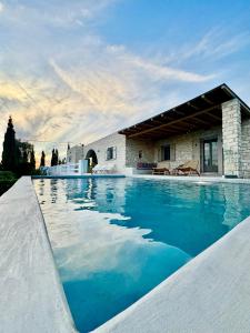 a swimming pool in front of a house at Villa Giorgianna -near Aliki beach with pool in Aliki