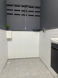 a white kitchen with a sink and a counter at Rossini Homestay in Muar