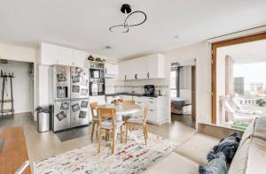 a kitchen with white cabinets and a table and chairs at Chic Appartement Sacré Cœur of Paris with Parking in Paris +14 photos