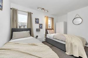 a bedroom with two beds and a window at Wherstead Rd House By Homestyles Hosts Short Lets & Serviced Accommodation Suffolk With Free Parking in Ipswich