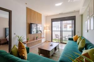 a living room with a green couch and a table at The Sunset Apartment - 2 BR & Beach-Front in Tangier