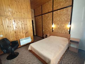 a bedroom with a bed and a chair in it at Urban Monkey Tent hostel & bar in Karakol