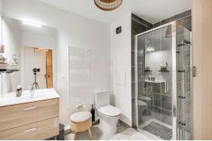 a bathroom with a shower and a toilet and a sink at Chic Appartement Sacré Cœur of Paris with Parking in Paris