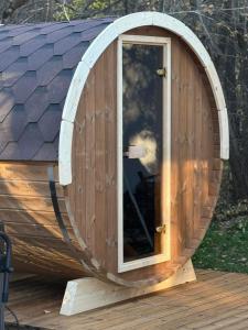 a wooden dog house with a window on a deck at Villa Yarema Mountain Relax with Hot Jacuzzi & Sauna by BookVillaBG in Zheleznitsa