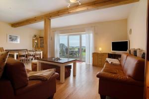 a living room with a couch and a table at Ferienhaus Poggenkrug Halbsguth in Wolgast