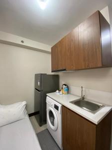 uma pequena cozinha com pia e máquina de lavar em Yuki's Place 1516 em Lapu Lapu City