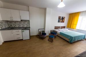 a bedroom with a bed and a kitchen with chairs at Şirin Apartrooms in Pamukkale