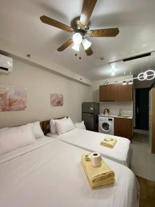 um quarto com duas camas e um ventilador de teto em Yuki's Place 1516 em Lapu Lapu City