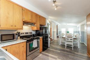 Una cocina con gabinetes de madera y una mesa con sillas. en Blue Ivy, en Port Aransas 17 fotos más