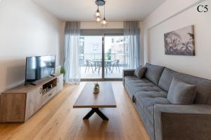 a living room with a couch and a tv and a table at Waylink Residences - Marina Floisvou in Athens