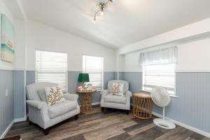 sala de estar con 2 sillas y ventilador en Blue Ivy, en Port Aransas