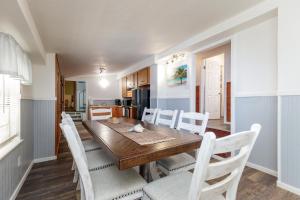 Un comedor con una mesa de madera y sillas blancas. en Blue Ivy, en Port Aransas