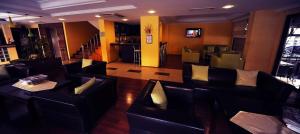 a restaurant with black leather couches and a bar at Şehri Saray Otel in Seyhan