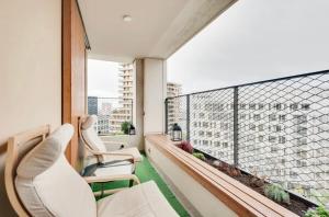 a balcony with two chairs and a large window at Chic Appartement Sacré Cœur of Paris with Parking in Paris