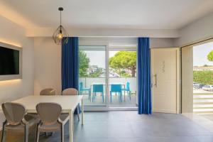 una sala da pranzo con tende blu e tavolo e sedie di Park Gallanti a Lido di Pomposa