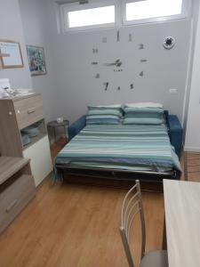 una camera da letto con un letto con un orologio a parete di Casetta di Renata a Lido di Ostia