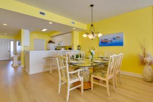 une salle à manger avec des murs jaunes, une table et des chaises dans l'établissement Navarre Condo with Beach Access and Ocean Views!, à Navarre