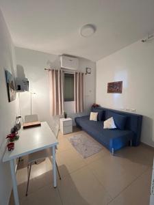 a living room with a blue couch and a table at The Shining Star -A beautiful 3 bedroom apartment in Beer Sheva