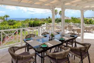a dining room with a table and chairs and the ocean at Oleanda - Sugar Hill in Saint James