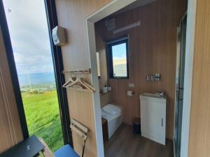 a small bathroom with a toilet and a window at Aorangi Peak Cabins 5 by Tiny Away in Rotorua