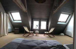una camera con un letto e due sedie e finestre di La Maison de pêcheur a Sarzeau