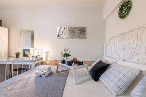 a bedroom with a large white bed and a table at Cocomelo Apts in Heraklio Town
