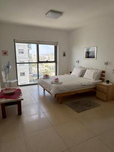 a bedroom with a large bed and a large window at The Shining Star -A beautiful 3 bedroom apartment in Beer Sheva