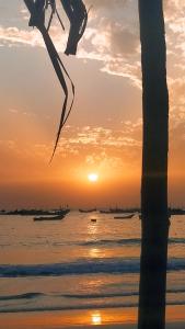 a sunset on the beach with boats in the water at Baafeh Beach in Sanyang